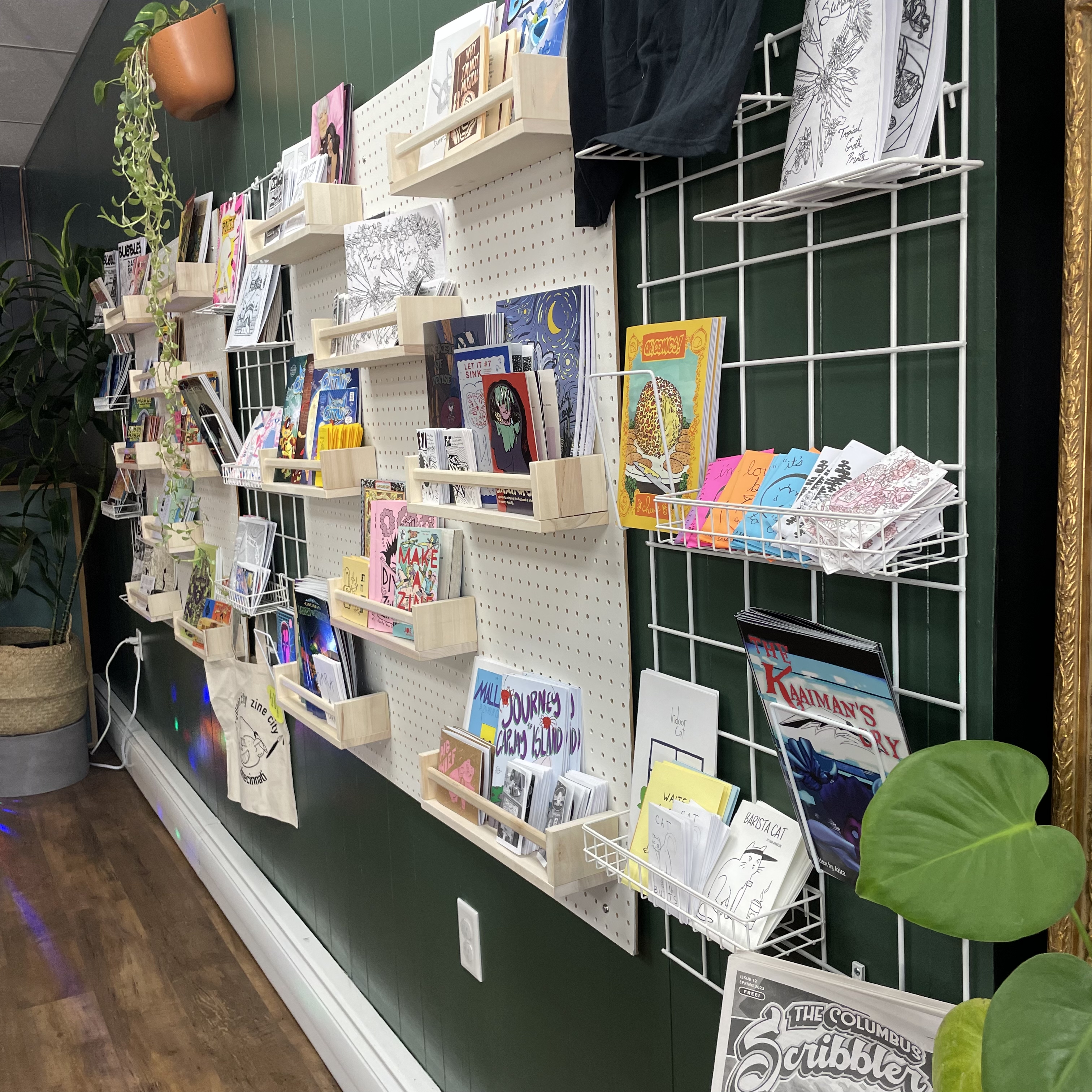 a photo of the interior of iNK, showing some plants and the zine wall